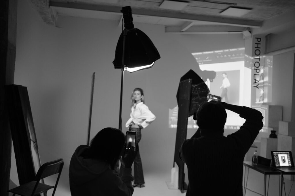 Capturing a professional black and white studio photoshoot with a model and photographers.